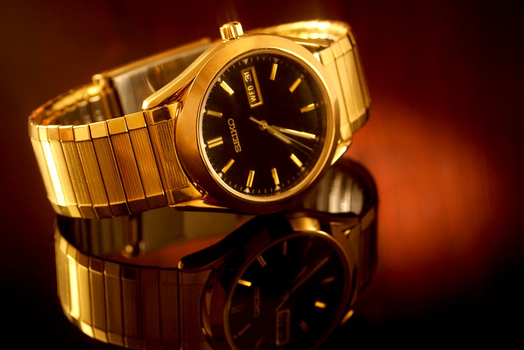 A gold watch against a stylized background.
