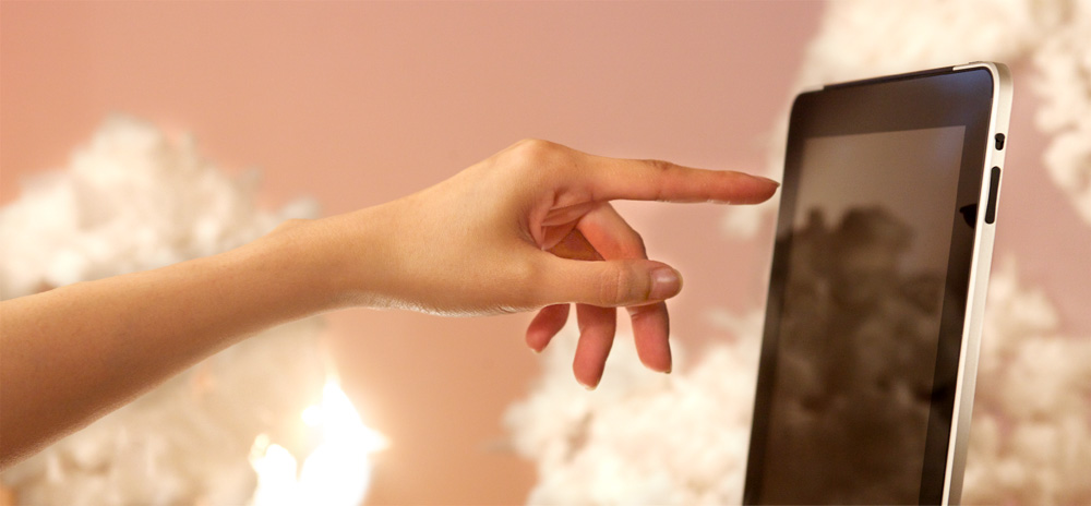 Hand reaching out and touching an iPad.